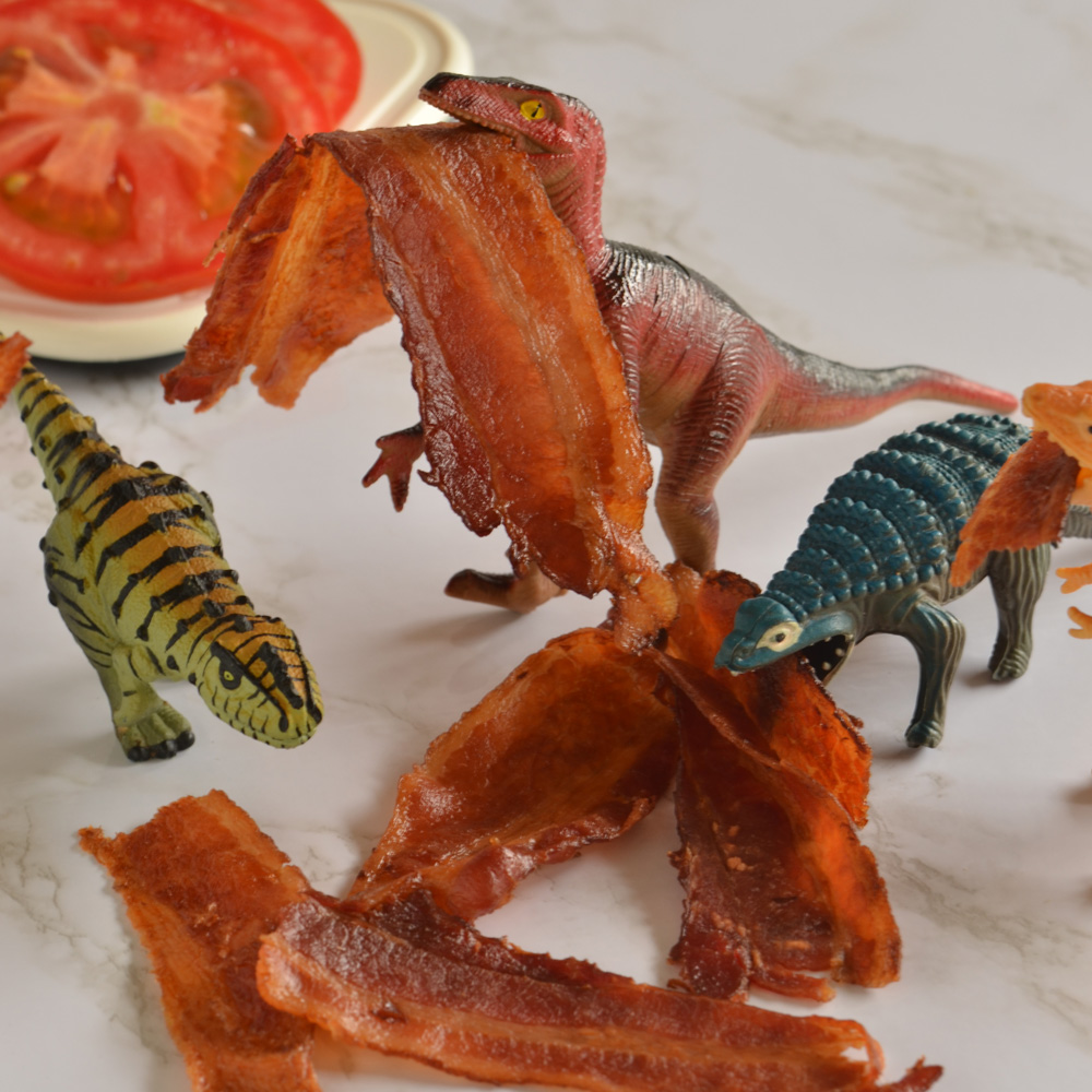 Unknown dinosaur, Oswald, and Alex eating bacon