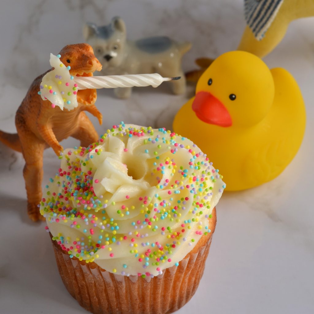 Blondie holds a birthday candle in their mouth.