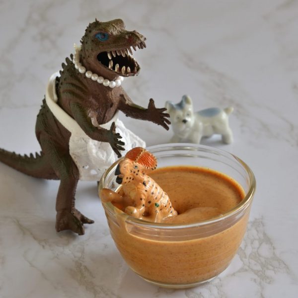 Spike is in a small bowl of peanut butter