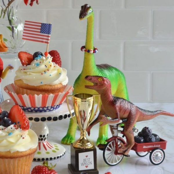 Dinosaurs celebrate the 4th of July with cupcakes, flags and a trophy.