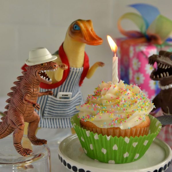 TJ and Dean look at the burning birthday candle on TJ's cupcake